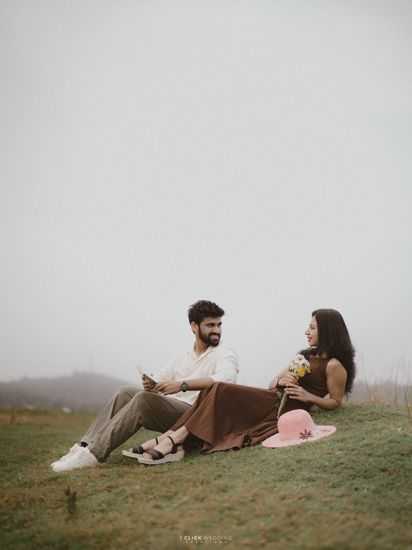 A couple sitting together in an open landscape